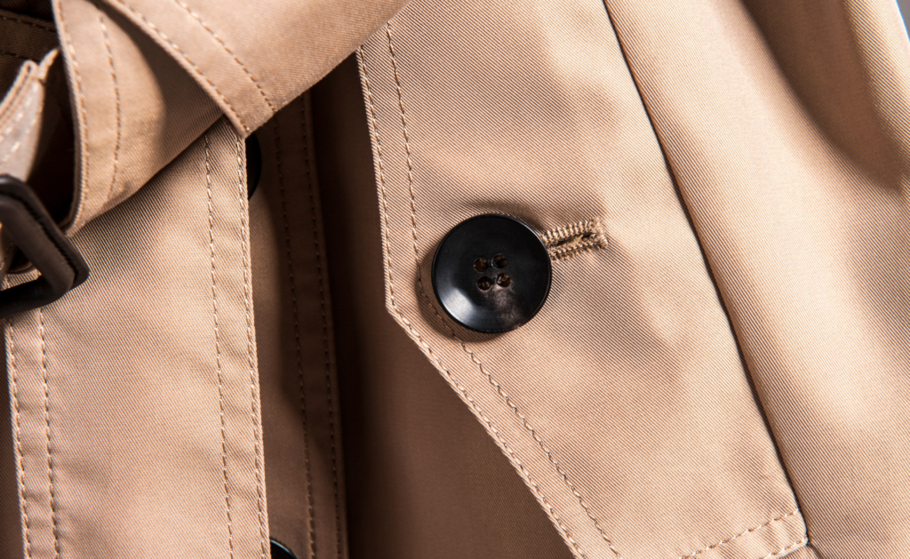 Close up of a stylish trench coat with detailed buttons and fabric texture